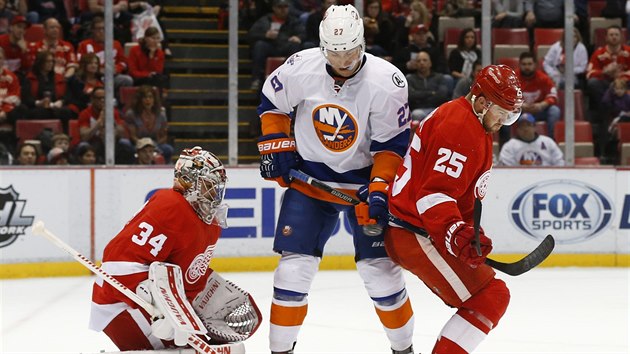 Brank Detroitu Petr Mrzek v obtn situaci: ped nm clon Anders Lee z New York Islanders i jeho spoluhr Mike Green.