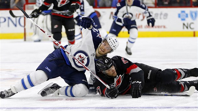 Michal Jordn z Caroliny (vpravo) a Joel Armia z Winnipegu skonili po kolizi na led.