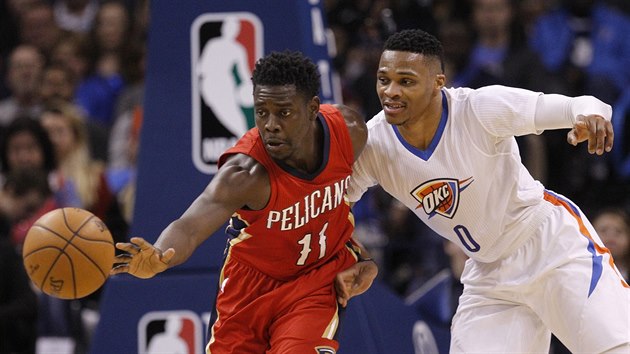 Jrue Holiday (vlevo) z New Orleans b pro m, Russell Westbrook se ho sna zastavit faulem.