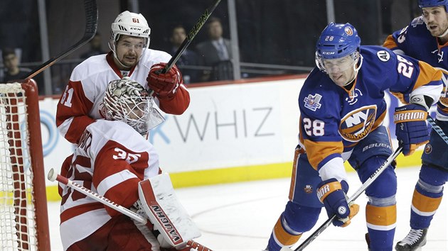 Marek idlick (28) z New York Islanders pekonv detroitskho glmana Jimmyho Howarda.