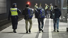 Švédský policista doprovází běžence na nádraží Hyllie ve městě Malmö (19....