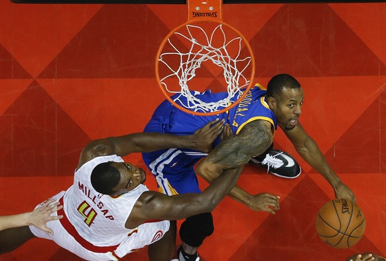 Pod koem bojují o mí Andre Iguodala (v modrém) z Golden State a Paul Millsap...