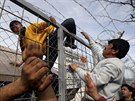 Migrant pelezá plot na ecko-makedonské hranici poblí vesnice Idomeni....