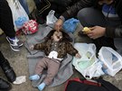Syrský uprchlík krmí své dít banánem, zatímco ekají na cestu dál do Evropy v...