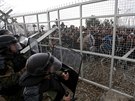 Policisté brání plot na ecko-makedonské hranici, který se migranti pokusili...
