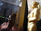 Fanouci se fotí se sochami Oscar podél erveného koberce