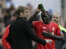 Mamadou Sakho z Liverpoolu si polévá hlavu vodou a naslouchá svému trenérovi...