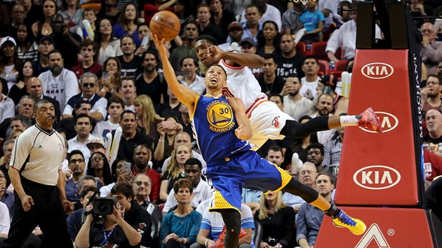 Stephen Curry z Golden State se pokouí o stelbu, fauluje ho Josh Richardson z...