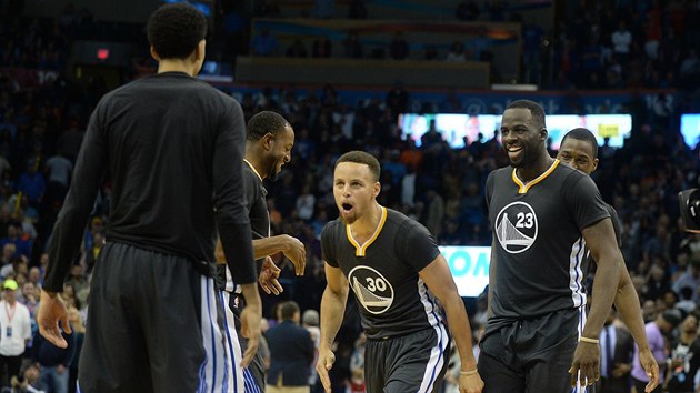 Stephen Curry (. 30) z Golden State prv rozhodl souboj s Oklahoma City, za nm se checht Draymond Green.