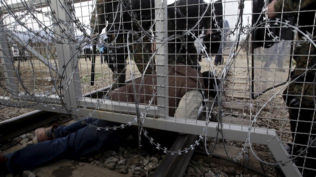 Migrant podlz hranin bariru plot na ecko-makedonsk hranici pobl vesnice Idomeni. Makedonie uzavela hranici pro Afghnce a poaduje dkladnj indentifikaci lid, kte m do zpadn Evropy (22. nora 2016).