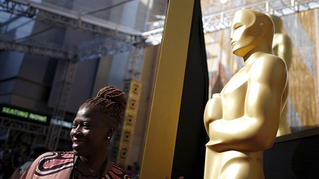 Fanoušci se fotí se sochami Oscarů podél červeného koberce