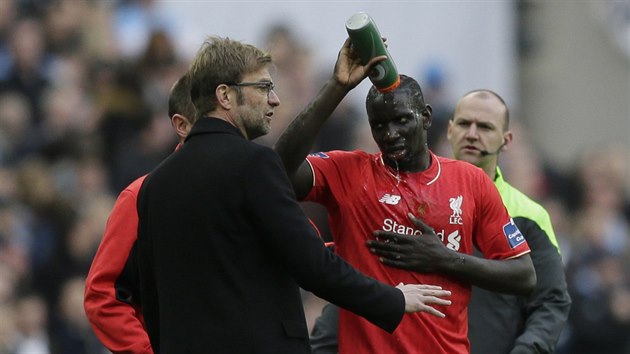 Mamadou Sakho z Liverpoolu si polv hlavu vodou a naslouch svmu trenrovi Jrgenu Kloppovi.