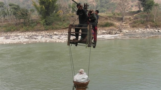 Lid z vesnice Dhading v oblasti Benighat v Neplu se dostvaj pes eku v chatrnch devnch boxech - pev tak sebe i zbo na trh.