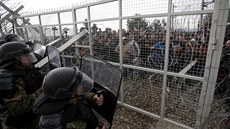 Policisté brání plot na ecko-makedonské hranici, který se migranti pokusili...