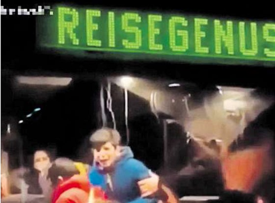 Zábr z videa zachycujícího vystupování migrant z autobusu v Clausnitzu. Nápis...