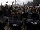 Uprchlíci stojící ped kordonem eckých policist na ecko-makedonských...