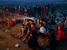 Děti běženců koukají na pohádky na poli u Idomeni, kde čekají na povolení...