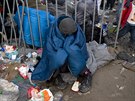 Uprchlík se sna�í zah�át po propr�ené noci v tábo�e Idomeni u �ecko-makedonské...