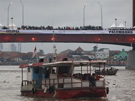 Most v Palembangu na ostrov Sumatra se zaplnil lidmi, kteí tam sledovali...