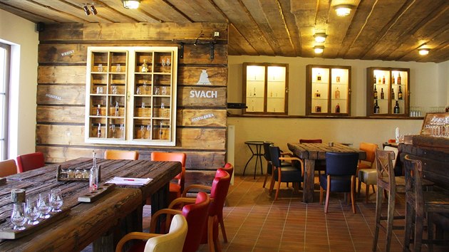Ve stylovém baru jsou stoly z původních stropních trámů a stěna z podlahových prken.
