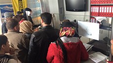 Migranti se snaí získat lístek na trajekt. (5. bezna 2016)