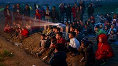 Dti benc koukají na pohádky na poli u Idomeni, kde ekají na povolení...