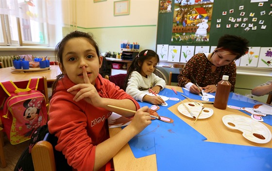 Dívky Sandra a Natálka vybarvují papírová zvířátka pod vedením učitelky Venduly...