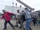 Migranti v eckém táboe Idomeni vedou na provizorní policejní stanici mue,...