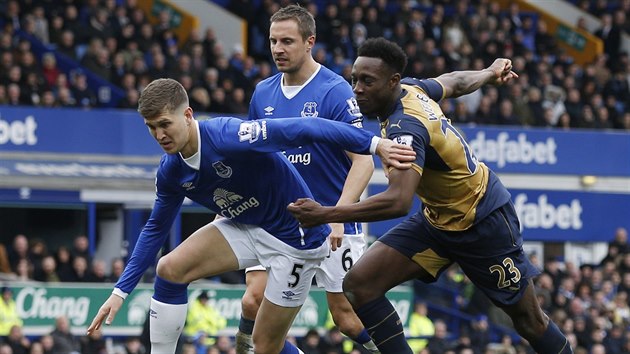 St��daj�c� obr�nce Evertonu John Stones (��slo 5) bojuje o balon s Dannym Welbeckem v dresu Arsenalu.