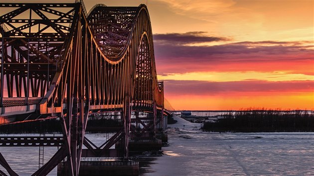 SIBISK PANORAMATA. Slunce zapad za mostem pes zamrzl Irty. Pou 4 248 kilometr dlouhho veletoku za Chanty-Mansijskem kon soutokem s Obem.
