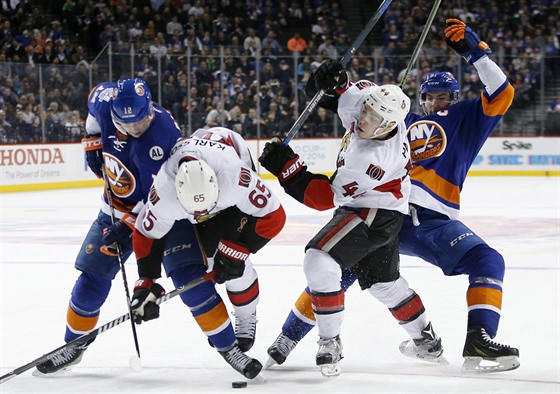 Boj o puk v duelu NY Islanders (modrá) vs. Ottawa. Zleva: Josh Bailey, Erik...