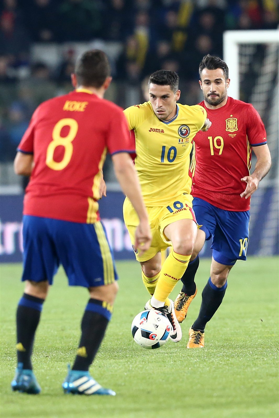 Rumunský fotbalista Nicolae Claudiu Stanciu  se sna�í projít mezi Kokem (vlevo)...