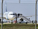 Proputní cestující vystupují z uneseného Airbusu (29. bezna 2016).