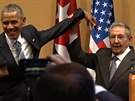 Raúl Castro zvedá hodn divn Obamovu ruku. Podívejte se