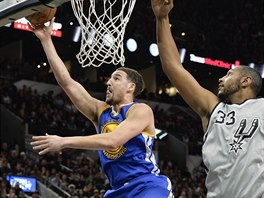 Klay Thompson (vlevo) z Golden State zakonuje pes brncho Borise Diawa ze...