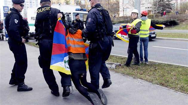 Nvtvu nskho prezidenta doprovzej i protesty, jednu z protestujcch s tibetskou vlajkou odvdj policist. (28. bezna 2016)