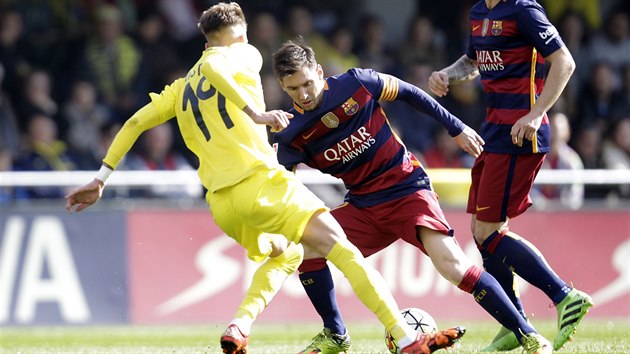 Samuel Castillejo z Villarrealu (ve lutm) se sna zastavit Lionela Messiho z Barcelony.