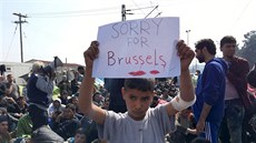 Chlapec v táboe Idomeni drí transparent Je mi líto Bruselu (23. bezna 2016)