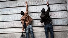 Dva mui píí osobní vzkazy u pietního místa v centru Bruselu. (23. bezna 2016)