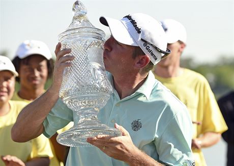 Americký golfista Jim Herman líbá trofej pro vítze Houston Open.