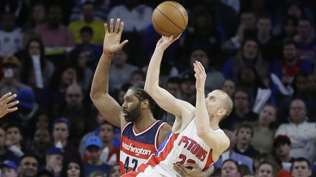 Steve Blake z Detroitu (v blm) se pokou o stelbu, fauluje ho Nene z Washingtonu.