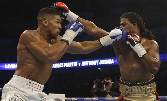 Anthony Joshua (vlevo) bojuje s Charlesem Martinem o titul ampiona tké váhy...