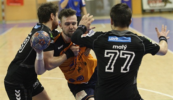 Plzeský házenká Michal Tonar se proplétá mezi protihrái z Lovosic.
