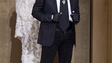 Lagerfeldův klasický outfit: černý oblek, bílá košile, černé rukavice a...