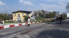 Chodci p�echázejí p�es p�ejezd ve Veleslavín�, p�esto�e jsou sta�ené závory.