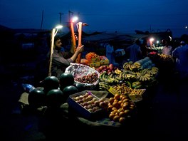 OVOCNÁ. Pákistánský prodava nabízí ke koupi ovoce pi soumraku v hlavním...