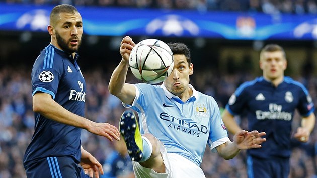 Jesus Navas z Manchesteru City se sousted na zpracovn me ped Karimem Benzemou z Realu Madrid.