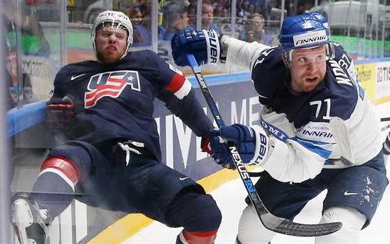 Finský hokejista Leo Komarov (v bílém) bojuje s americkým protivníkem J. T....