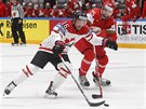 Kanadský hokejista Max Domi uniká, brání ho Oleg Jevenko z Bloruska.