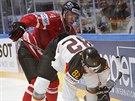Kanadský hokejista Taylor Hall (vlevo) atakuje Sinana Akdaga z Nmecka.
